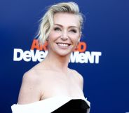 Portia de Rossi in a black and white shoulderless dress on a red carpet for Arrested Development