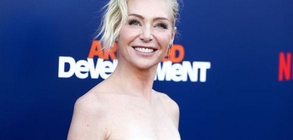 Portia de Rossi in a black and white shoulderless dress on a red carpet for Arrested Development