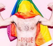 A gay otter flexing his arms with a Pride flag draped over his head
