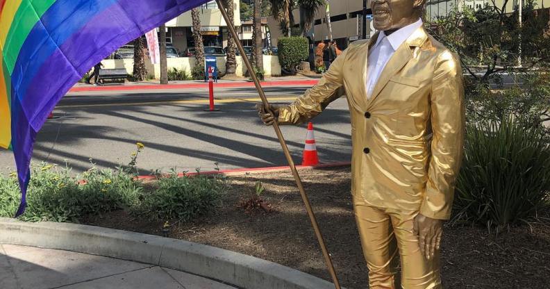 Photo of the Kevin Hart statue holding a rainbow flag.