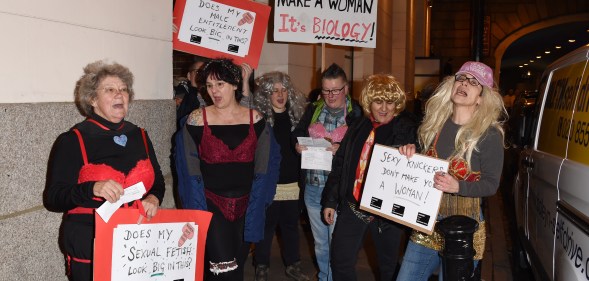 anti-trans protesters picket a transgender lingerie show