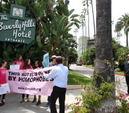 A security guard confronts demonstrators protesting the introduction of laws targeting women and LGBT people in Brunei, outside the Sultan-owned Beverley Hills Hotel