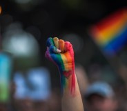 LGBT rainbow painted fist punched in air with celebration