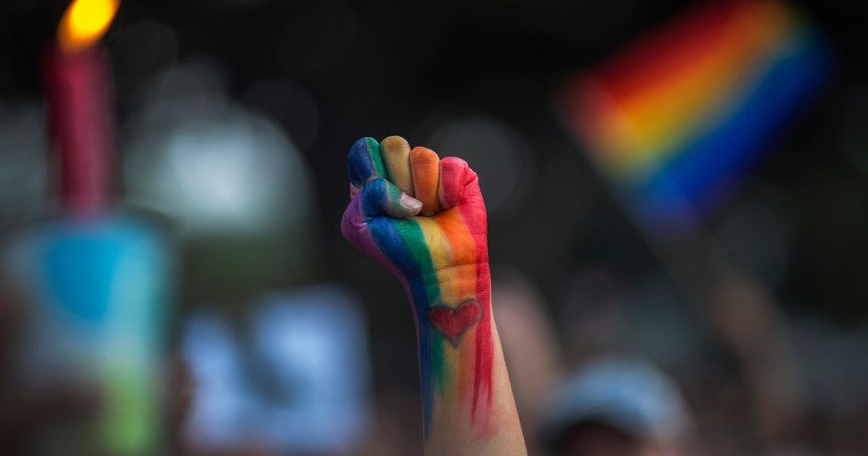 LGBT rainbow painted fist punched in air with celebration