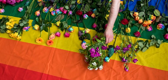 Demonstrators lay roses on a rainbow flag as they protest over an alleged Chechnya anti-gay purge outside the Russian Embassy in London on June 2, 2017.