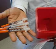 A doctor holds needles