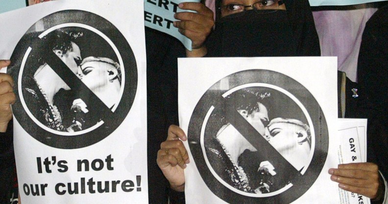Malaysian Muslim students hold placards during a protest against the US glam rocker Adam Lambert's concert in Bukit Jalil, outside Kuala Lumpur, on October 14, 2010.