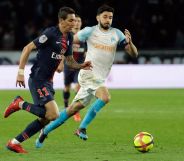 Paris Saint-Germain's Angel Di Maria vies with Marseille's Morgan Sanson for a ball.