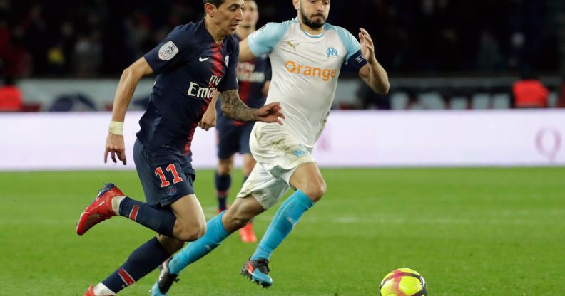 Paris Saint-Germain's Angel Di Maria vies with Marseille's Morgan Sanson for a ball.