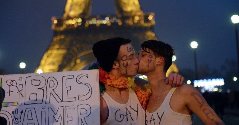 Gay couple kiss in Paris, France.