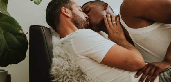 Gay couple kissing on sofa