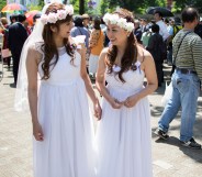 A Japanese same-sex couple in wedding attire takes part in the Tokyo Rainbow Pride Parade on May 6, 2018 in Tokyo, Japan