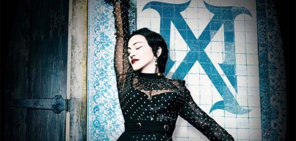 Madonna as Madame X, standing against a wall