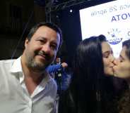 Matteo Salvini next to two women kissing.