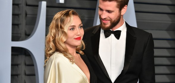 Miley Cyrus (L) and Liam Hemsworth attend the 2018 Vanity Fair Oscar Party hosted by Radhika Jones at Wallis Annenberg Center for the Performing Arts on March 4, 2018 in Beverly Hills, California.