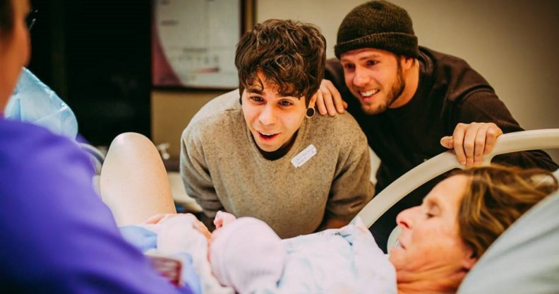 Matthew Eledge and husband Elliot Dougherty look on as Cecile Reynek Eledge holds newborn Uma Louise Dougherty-Eledge.