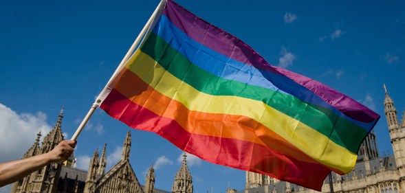 A protester holds a rainbow flag outside the Houses of Parliament in central London on June 3, 2013, as protesters gather in support of same-sex marriage