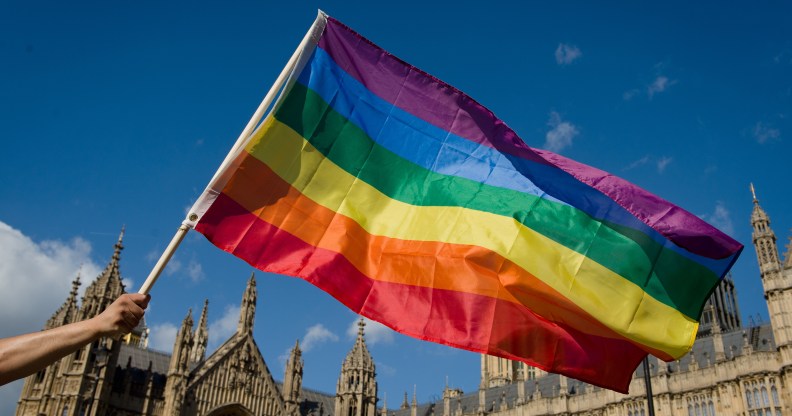 A protester holds a rainbow flag outside the Houses of Parliament in central London on June 3, 2013, as protesters gather in support of same-sex marriage