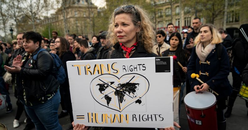 A woman holding a sign which reads "trans rights are human rights"