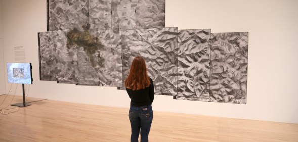A woman views a video piece by artist Forensic Architecture during the Turner Prize 2018.