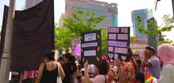 Protesters hold pro-equality signs and LGBT flags at the women's march in Malaysia