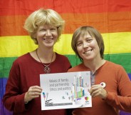 Founders Anna and Yulia pose with the logo for this year's conference, which did not go ahead as planned after LGBT+ activists were targeted in an attack.