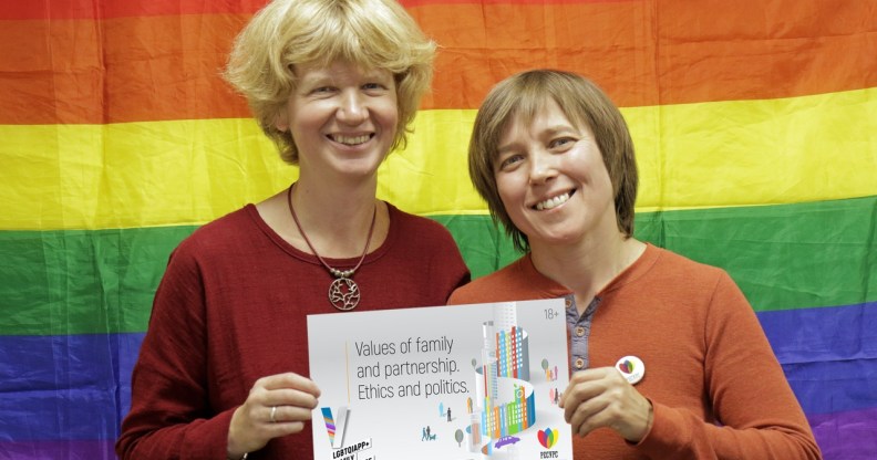 Founders Anna and Yulia pose with the logo for this year's conference, which did not go ahead as planned after LGBT+ activists were targeted in an attack.