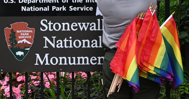 A National Park Service ranger places rainbow flags on the fence at the Stonewall National Monument in the West Village neighborhood of Greenwich Village in Lower Manhattan, New York City on June 19, 2019.