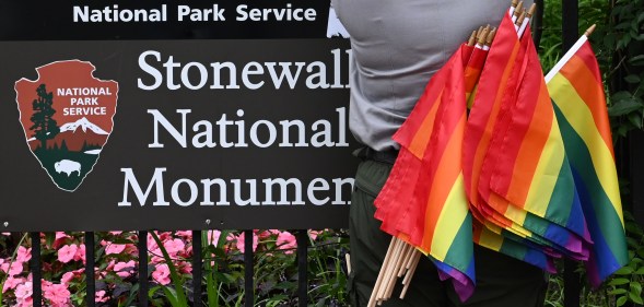 A National Park Service ranger places rainbow flags on the fence at the Stonewall National Monument in the West Village neighborhood of Greenwich Village in Lower Manhattan, New York City on June 19, 2019.