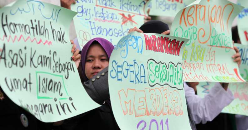 Protesters raise placards during a protest outside a corridor Mosque in Shah Alam near Kuala Lumpur on November 4, 2011. The demonstration was to urge the goverment to give recognition to the lesbian, gay, bisexual and transgender (LGBT) community. AFP PHOTO/MOHD RASFAN (Photo credit should read MOHD RASFAN/AFP/Getty Images)