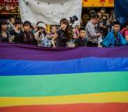 Participants carry a large flag as they take part in a Gay Pride procession in Hong Kong on November 10, 2012. As anti-discrimination laws continues to expand globally, the participant marched to promote equal rights for lesbian, gay, bisexual and transgender (LGBT). AFP PHOTO / Philippe Lopez (Photo credit should read PHILIPPE LOPEZ/AFP/Getty Images)