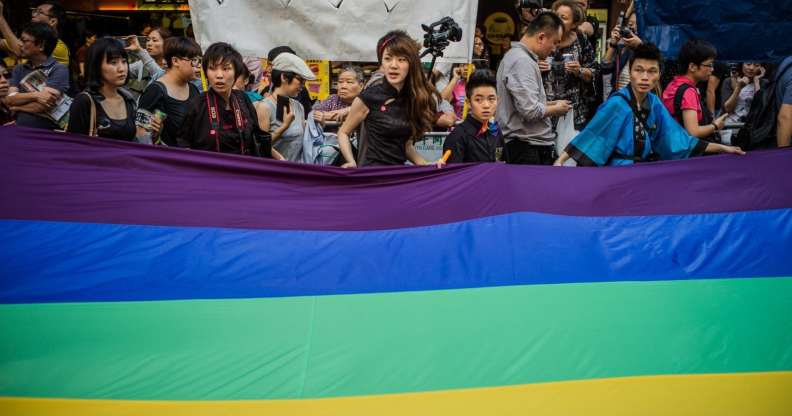 Participants carry a large flag as they take part in a Gay Pride procession in Hong Kong on November 10, 2012. As anti-discrimination laws continues to expand globally, the participant marched to promote equal rights for lesbian, gay, bisexual and transgender (LGBT). AFP PHOTO / Philippe Lopez (Photo credit should read PHILIPPE LOPEZ/AFP/Getty Images)