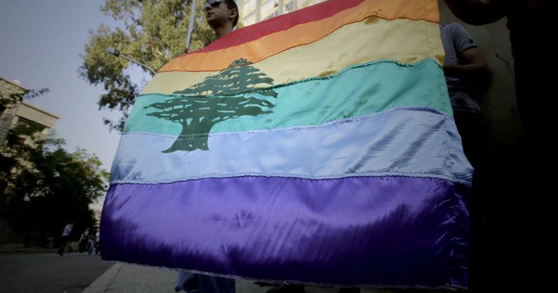 A gay pride flag bearing the cedar tree in the middle of it is carried by human rights activists during an anti-homophobia rally in Beirut on April 30, 2013. Lebanese homosexuals, human rights activists and members from the NGO Helem (the Arabic acronym of "Lebanese Protection for Lesbians, Gays, Bisexuals and Transgenders") rallied to condemn the arrest on the weekend of three gay men and one transgender civilian in the town of Dekwaneh east of Beirut at a nightclub who were allegedly verbally and sexually harassed at the municipality headquarters. AFP PHOTO/JOSEPH EID / AFP PHOTO / Joseph EID (Photo credit should read JOSEPH EID/AFP/Getty Images)