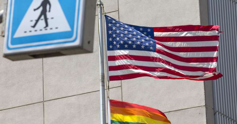 A Pride flag is raised next to the US flag.