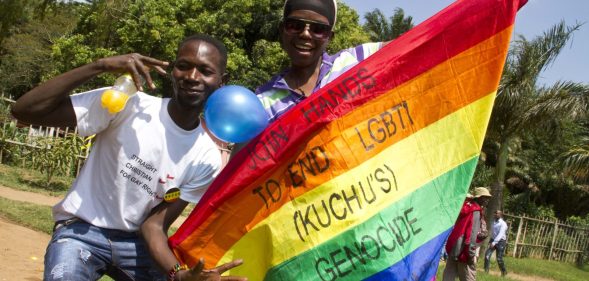 Uganda men hold a rainbow flag reading "Join hands to end LGBTI (Lesbian Gay Bi Trans Intersex - called Kuchu in Uganda) genocide" as they celebrate on August 9, 2014 during the annual gay pride in Entebbe, Uganda. Uganda's attorney general has filed an appeal against the constitutional court's decision to overturn tough new anti-gay laws, his deputy said on August 9. Branded draconian and "abominable" by rights groups but popular domestically, the six-month old law which ruled that homosexuals would be jailed for life was scrapped on a technicality by the constitutional court on August 1. AFP PHOTO/ ISAAC KASAMANI (Photo credit should read ISAAC KASAMANI/AFP/Getty Images)