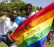Uganda men hold a rainbow flag reading "Join hands to end LGBTI (Lesbian Gay Bi Trans Intersex - called Kuchu in Uganda) genocide" as they celebrate on August 9, 2014 during the annual gay pride in Entebbe, Uganda. Uganda's attorney general has filed an appeal against the constitutional court's decision to overturn tough new anti-gay laws, his deputy said on August 9. Branded draconian and "abominable" by rights groups but popular domestically, the six-month old law which ruled that homosexuals would be jailed for life was scrapped on a technicality by the constitutional court on August 1. AFP PHOTO/ ISAAC KASAMANI (Photo credit should read ISAAC KASAMANI/AFP/Getty Images)