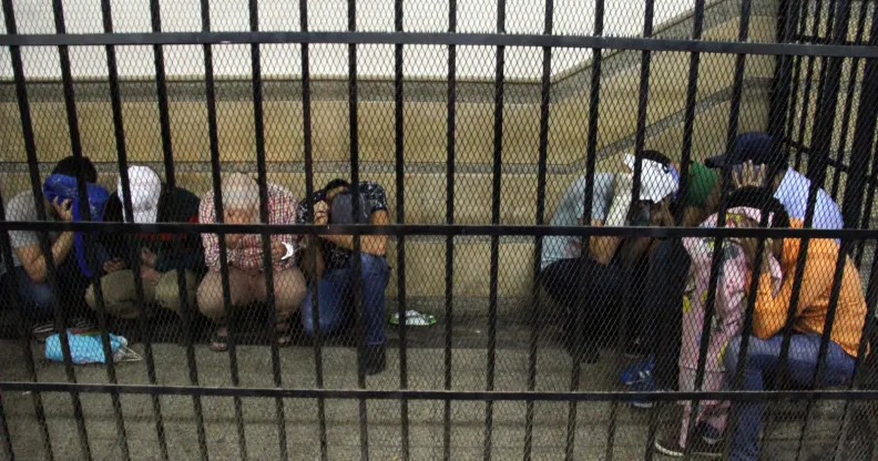 Eight Egyptian men on trial for doing a video prosecutors claimed was of a gay wedding hide their identities as they sit in the defendent's cage during their trial in Cairo on November 1, 2014. The video, filmed aboard a Nile riverboat, shows what prosecutors said was a gay wedding ceremony, with two men in the centre kissing, exchanging rings and cutting a cake with their picture on it. The Egyptian court jailed the eight men for three years. AFP PHOTO / STR (Photo credit should read -/AFP/Getty Images)