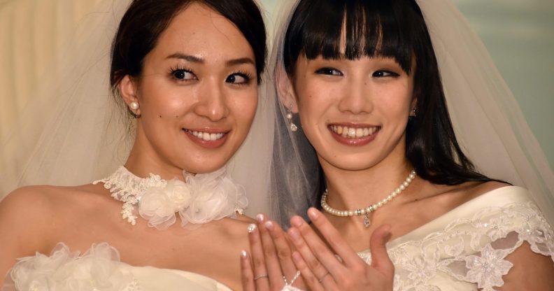 Japanese actress Akane Sugimori (R) and her partner Ayaka Ichinose, both dressed in white, display their wedding rings at a press conference after their marriage ceremony in Tokyo on April 19, 2015. The lesbian couple held a symbolic wedding ceremony in Tokyo, as calls grow for Japan to legalise same-sex marriage. While their marriage will not be recognised under law, actresses Ichinose, 34, and Sugimori, 28 tied the knot in front of some 80 relatives and friends. AFP PHOTO / Yoshikazu TSUNO (Photo credit should read YOSHIKAZU TSUNO/AFP/Getty Images)
