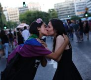 two womn kiss as they take part in the annual Gay Pride parade in Athens, on June 13, 2015. Greece's radical-left government on June 10, 2015, proposed a bill to grant same-sex couples the right to a civil union, two years after the European Court of Human Rights condemned the country's existing legislation as discriminatory. AFP PHOTO / ANGELOS TZORTZINIS (Photo credit should read ANGELOS TZORTZINIS/AFP/Getty Images)