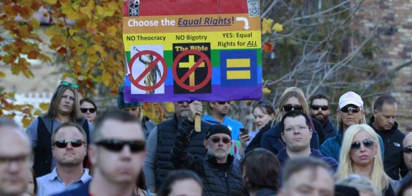 SALT LAKE CITY, UT - NOVEMBER14: A man holds a protest sign in City Creek Park after many submitted their resignations from the Church of Jesus Christ of Latter-Day Saints in response to a recent change in church policy towards married LGBT same sex couples and their children on November 14, 2015 in Salt Lake City, Utah. A little over a week ago the Mormon church made a change in their official handbook of instructions requiring a disciplinary council and possible excommunication for same sex couples and banning the blessing and baptism of their children into the church. (Photo by George Frey/Getty Images)