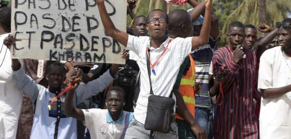 A protestor gestures on January 22, 2015 in Dakar during a demonstration against homosexuality. Under Senegalese law, anyone convicted of an "improper or unnatural act with a person of the same sex" faces up to five years in jail. The government has repeatedly ruled out legalising homosexuality in the deeply conservative Muslim-majority country. Banner reads "No fag". / AFP / SEYLLOU (Photo credit should read SEYLLOU/AFP/Getty Images)