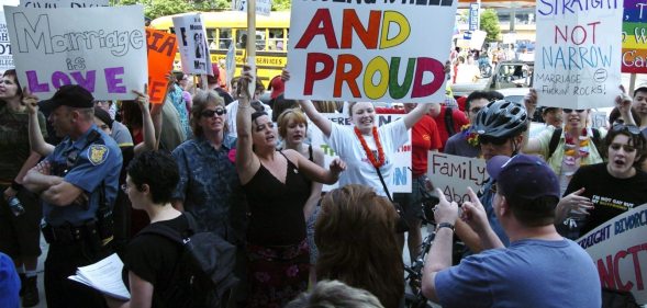 SEATTLE - MAY 1: Protestors hold signs and greet participants to a rally to affirm traditional marriage between a man and a woman on May 1, 2004 at Safeco Field in Seattle. The special speaker was James Dobson, founder of the evangelical Christian group called "Focus on the Family". The event was organized by local Christian groups and drew approximately 20,000 people as well as about 3,000 protestors, according to police. (Photo by Ron Wurzer/Getty Images)