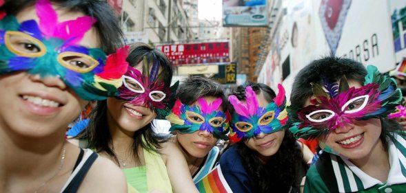 HONG KONG, CHINA: Gay activists wearing masks attend a gathering and march in the Causeway Bay district of Hong Kong, 16 May 2005. Some 350 people from various backgrounds gathered 16 May to raise public awareness for the first time on homophobia and promote diversity. AFP PHOTO/TED ALJIBE (Photo credit should read TED ALJIBE/AFP/Getty Images)