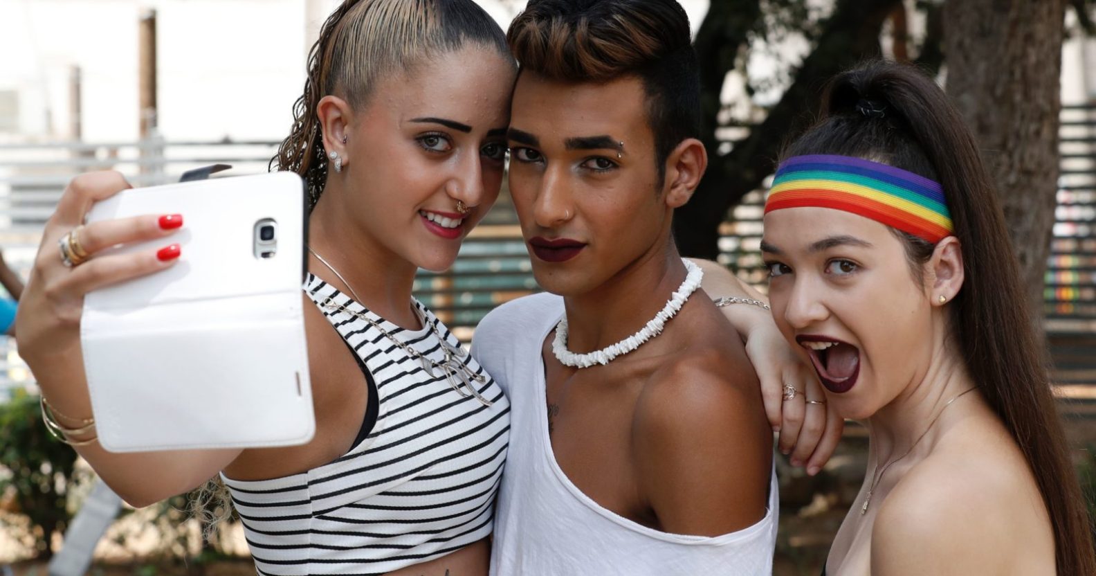 Participants use a phone to take a selfie at the opening event of the annual Gay Pride parade in the Israeli city of Tel Aviv, on June 3, 2016. A carefree and cosmopolitan crowd of tens of thousands of homosexuals, transsexuals and supporters took part it the Gay Pride in Tel Aviv, deemed one of the largest in the world where amid the crowd, tourists waved large flags of their country of origin to signify their presence in a city known as a rare oasis for LGBT (lesbian, gay, bi-sexual and transgender) in the Middle East. / AFP / JACK GUEZ (Photo credit should read JACK GUEZ/AFP/Getty Images)