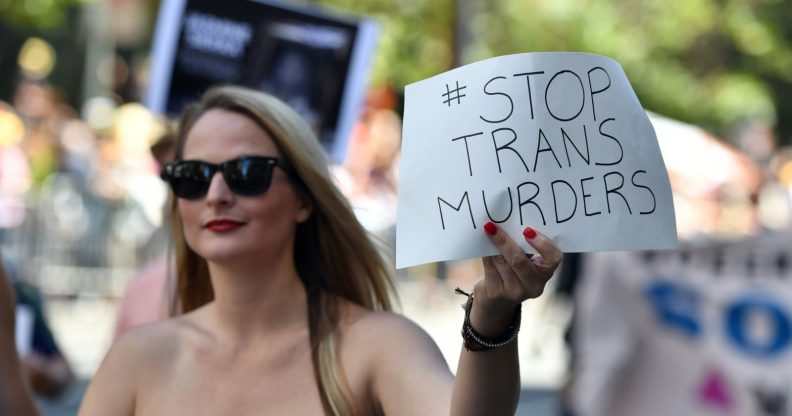 A woman holds up a sign that protests violence against transgender people while participating in the San Francisco Pride parade in San Francisco, California on Sunday, June, 26, 2016. / AFP / Josh Edelson (Photo credit should read JOSH EDELSON/AFP/Getty Images)