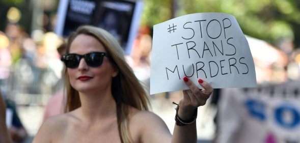 A woman holds up a sign that protests violence against transgender people while participating in the San Francisco Pride parade in San Francisco, California on Sunday, June, 26, 2016. / AFP / Josh Edelson (Photo credit should read JOSH EDELSON/AFP/Getty Images)