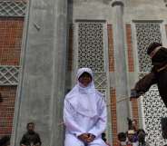 TOPSHOT - A religious officer canes an Acehnese youth onstage as punishment for dating outside of marriage, which is against sharia law, outside a mosque in Banda Aceh on August 1, 2016. The strictly Muslim province, Aceh has become increasingly conservative in recent years and is the only one in Indonesia implementing Sharia law. / AFP / CHAIDEER MAHYUDDIN (Photo credit should read CHAIDEER MAHYUDDIN/AFP/Getty Images)