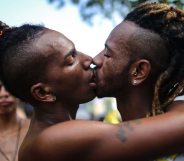 RIO DE JANEIRO, BRAZIL - DECEMBER 11: Revelers kiss during the annual gay pride parade on Copacabana beach December 11, 2016 in Rio de Janeiro, Brazil. Marchers called for expanded rights and protection from violence for those in the LGBT (Lesbian, Gay, Bisexual and Transgender) community. (Photo by Mario Tama/Getty Images)