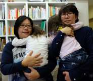 Same-sex couple Hope Chen (L), 37, and Zoro Wen, 34, pose with their twin daughters at their home in Taoyuan, northern Taiwan