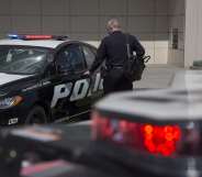 An LAPD officer, thepolice force currently investigating the second death of a black man at the home of gay Democrat donor Ed Buck, looks at a car.